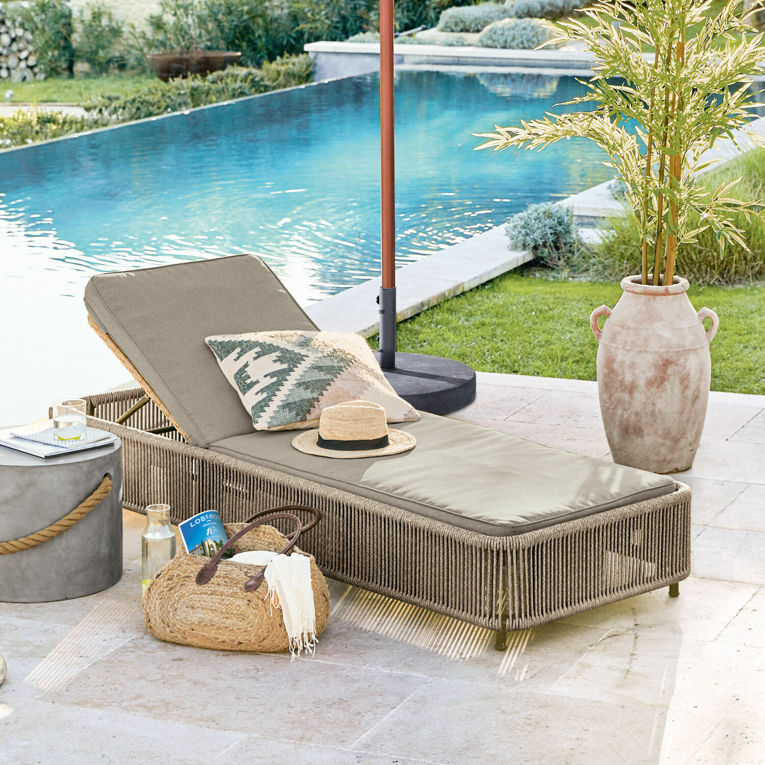 Chaise longue Huntville Chaise longue de jardin beige avec coussin et structure tressée près de la piscine, ambiance détente