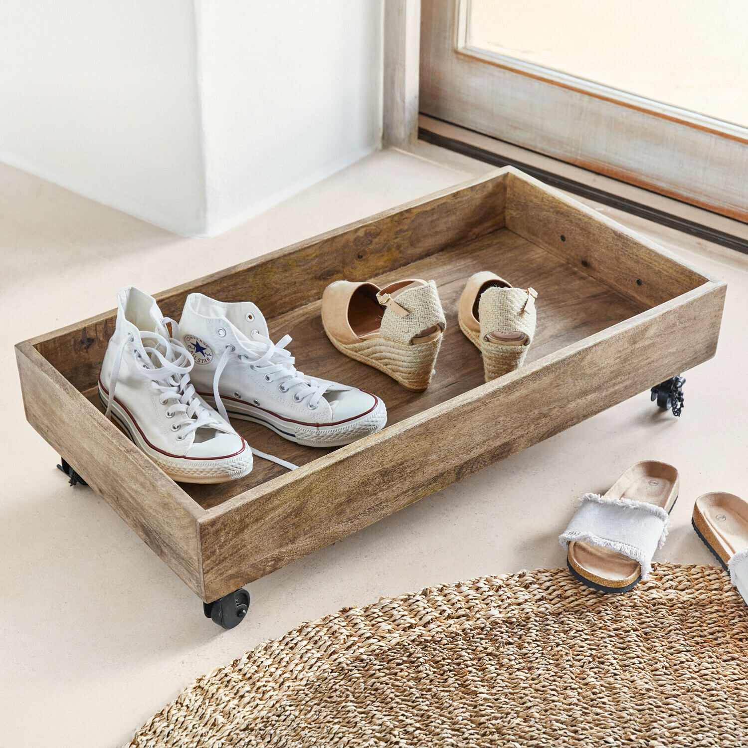 Houten dienblad op wieltjes met witte sneakers en beige sleehakken op de vloer