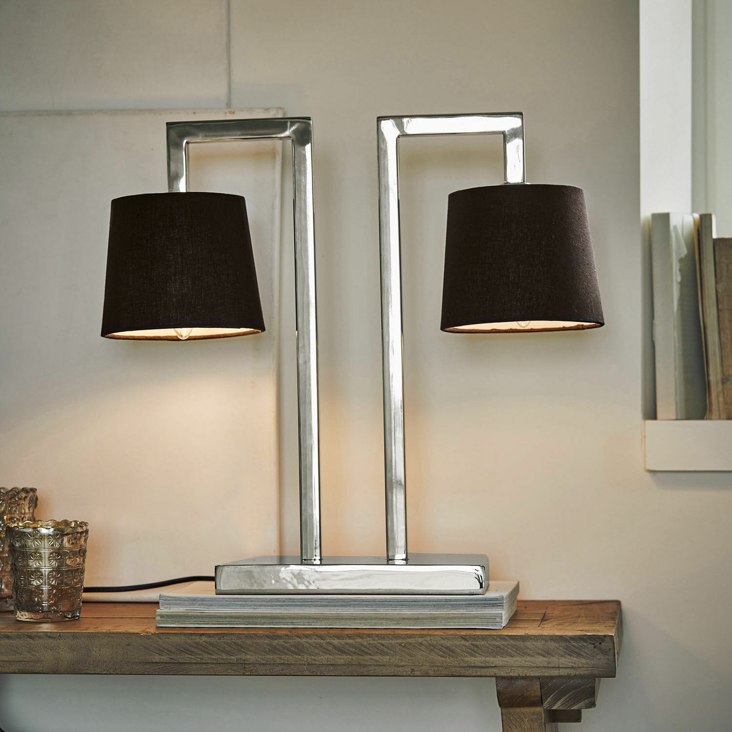 Lampe à poser St. Clair Lampe de table moderne avec base en métal et deux abat-jours noirs posée sur une table en bois
