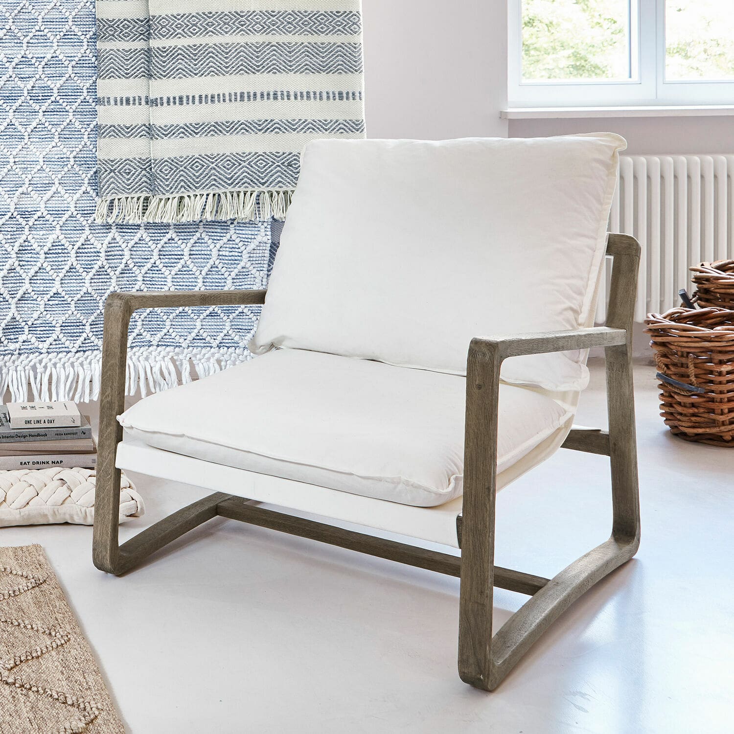 Fauteuil Jowna Stoel met houten frame en wit katoenen kussen in lichte, moderne kamer