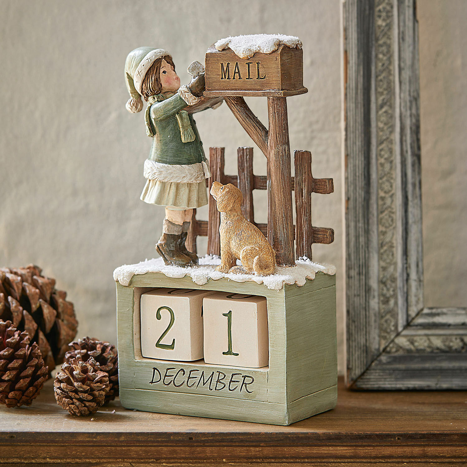 Calendrier Leonce Calendrier en bois avec figurine de fille et chien dans décor hivernal, tons verts et bruns