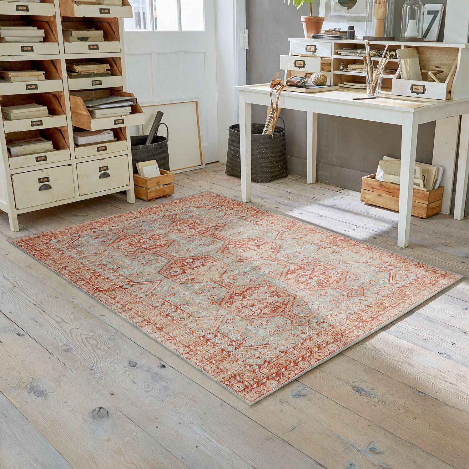 Tapis Incantaro Tapis à motif rouge et beige sur un sol en bois clair dans une pièce lumineuse et décorée vintage