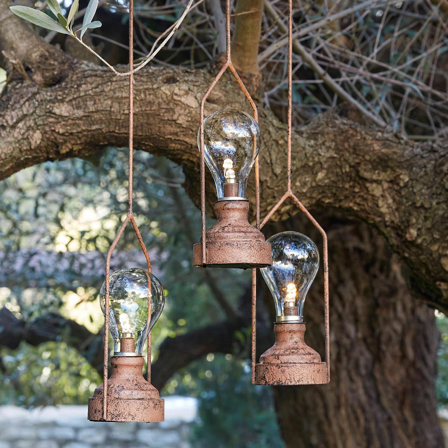 Lot de 3 lanternes LED à suspendre Chambéry Trois lampes suspendues en métal rouillé avec ampoules LED devant un arbre, éclairage décoratif extérieur