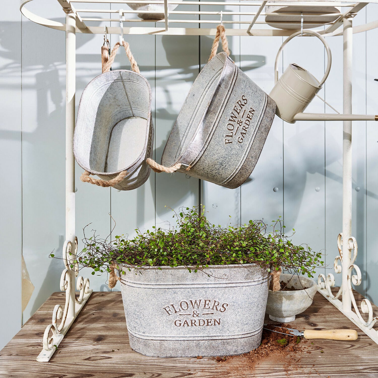 Sierpot set van 3 Merrin Grijze metalen plantenbakken met tekst Flowers & Garden, groene plant en tuingereedschap op houten tafel