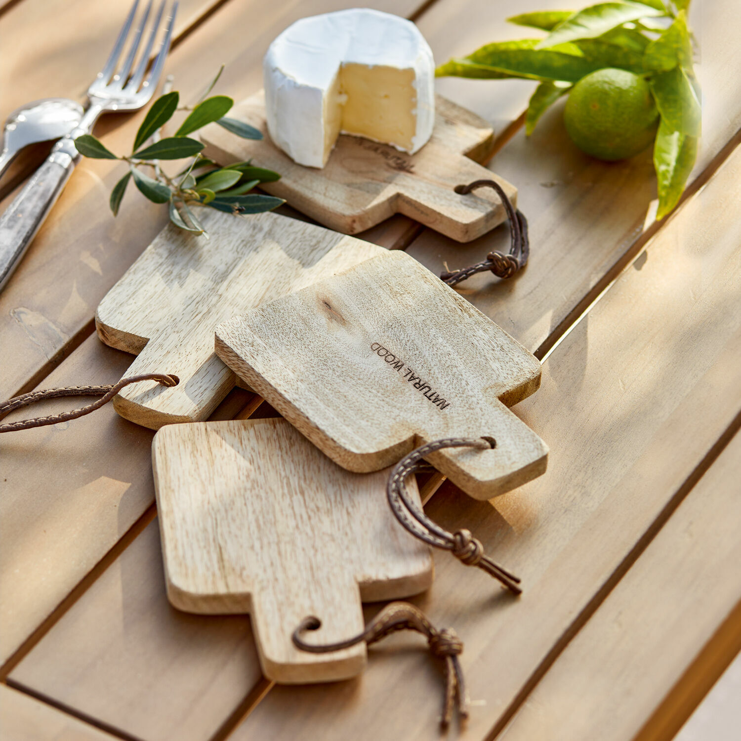 Snijplank set van 4 Boise Set natuurlijke houten snijplanken met handvatten en koord op tafel met kaas en limoen