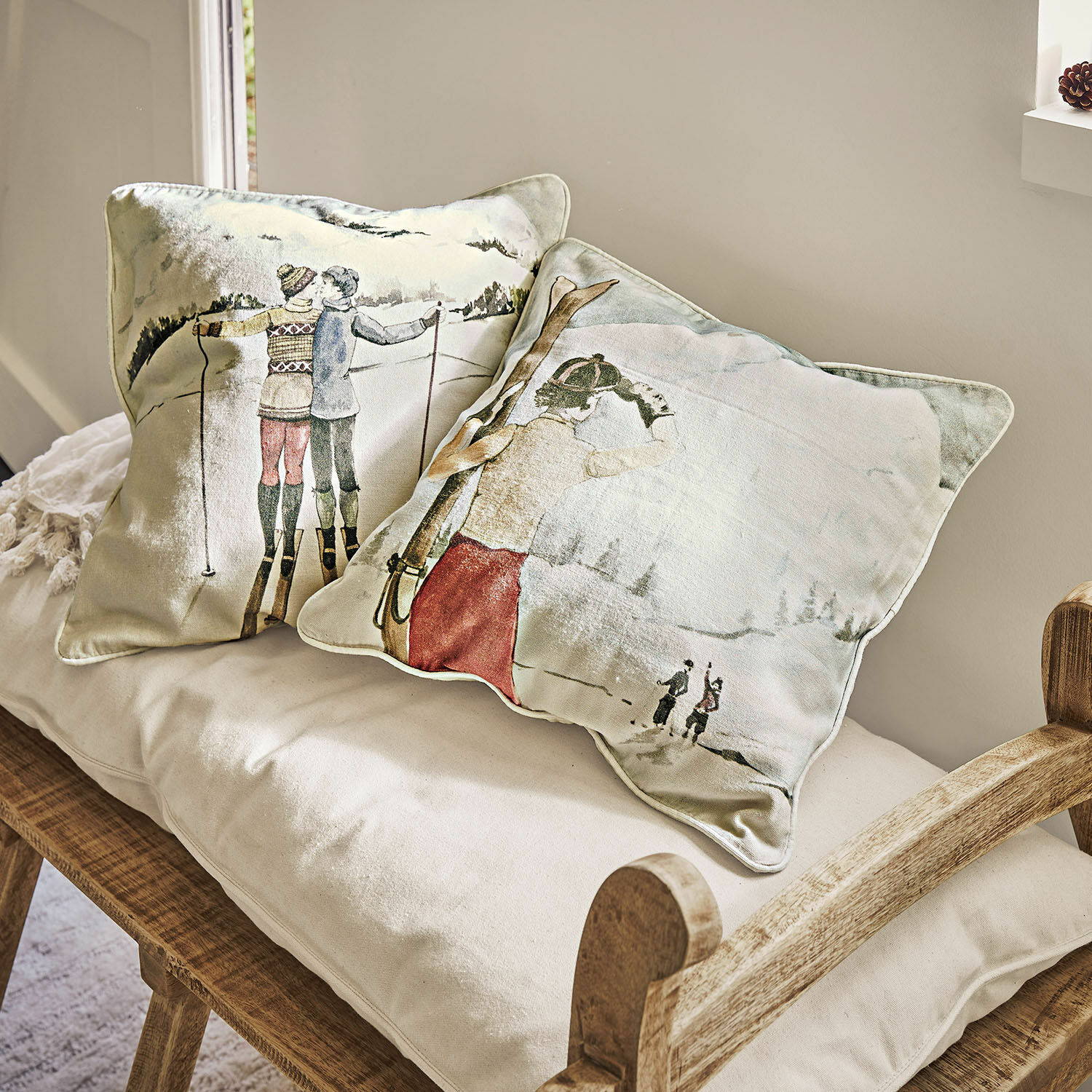 Lot de 2 housses de coussins Towyn Coussins décoratifs avec motif de ski d'hiver sur tissu clair posés sur un banc en bois