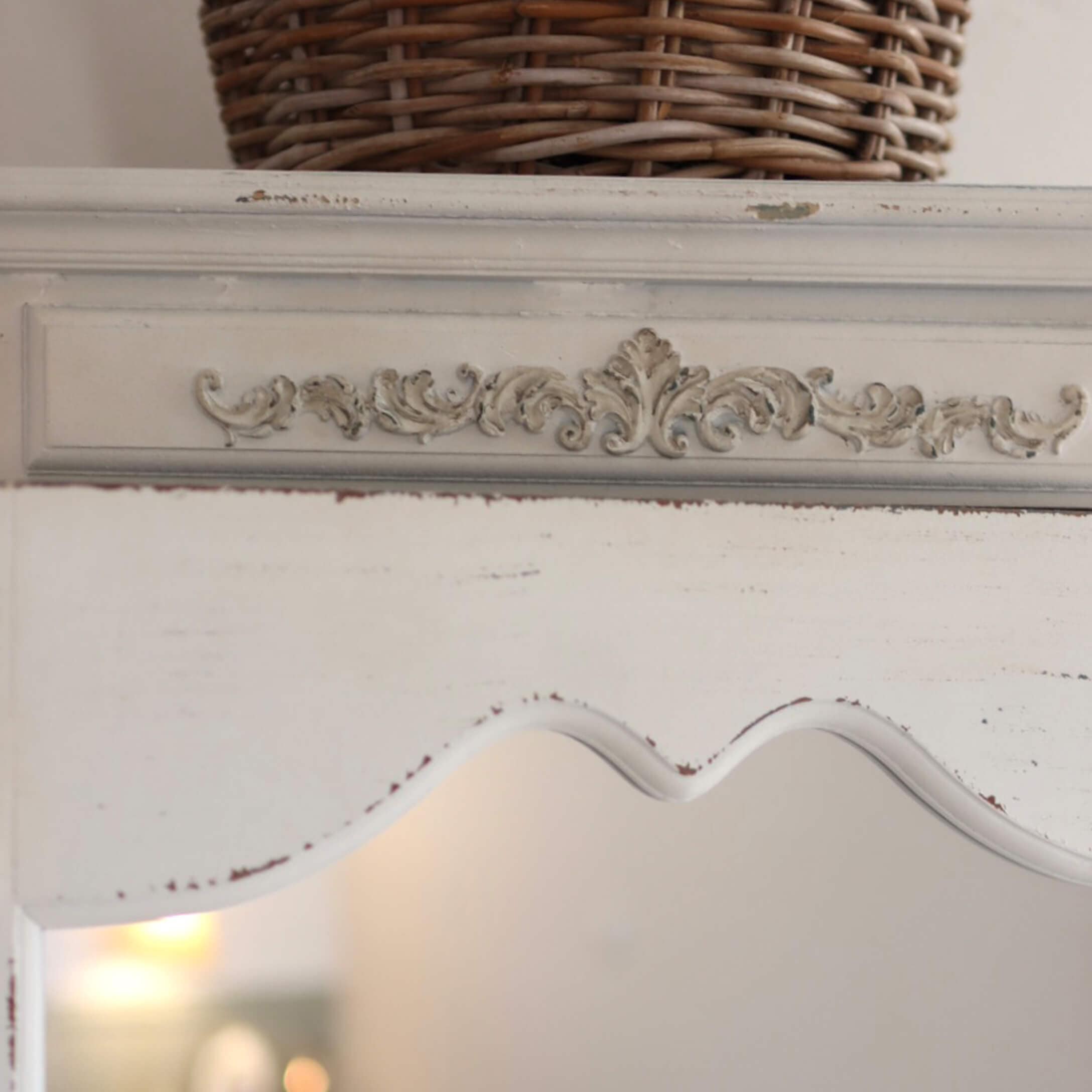 Meuble en bois blanc avec motif sculpté décoratif et finition vieillie pour un style vintage