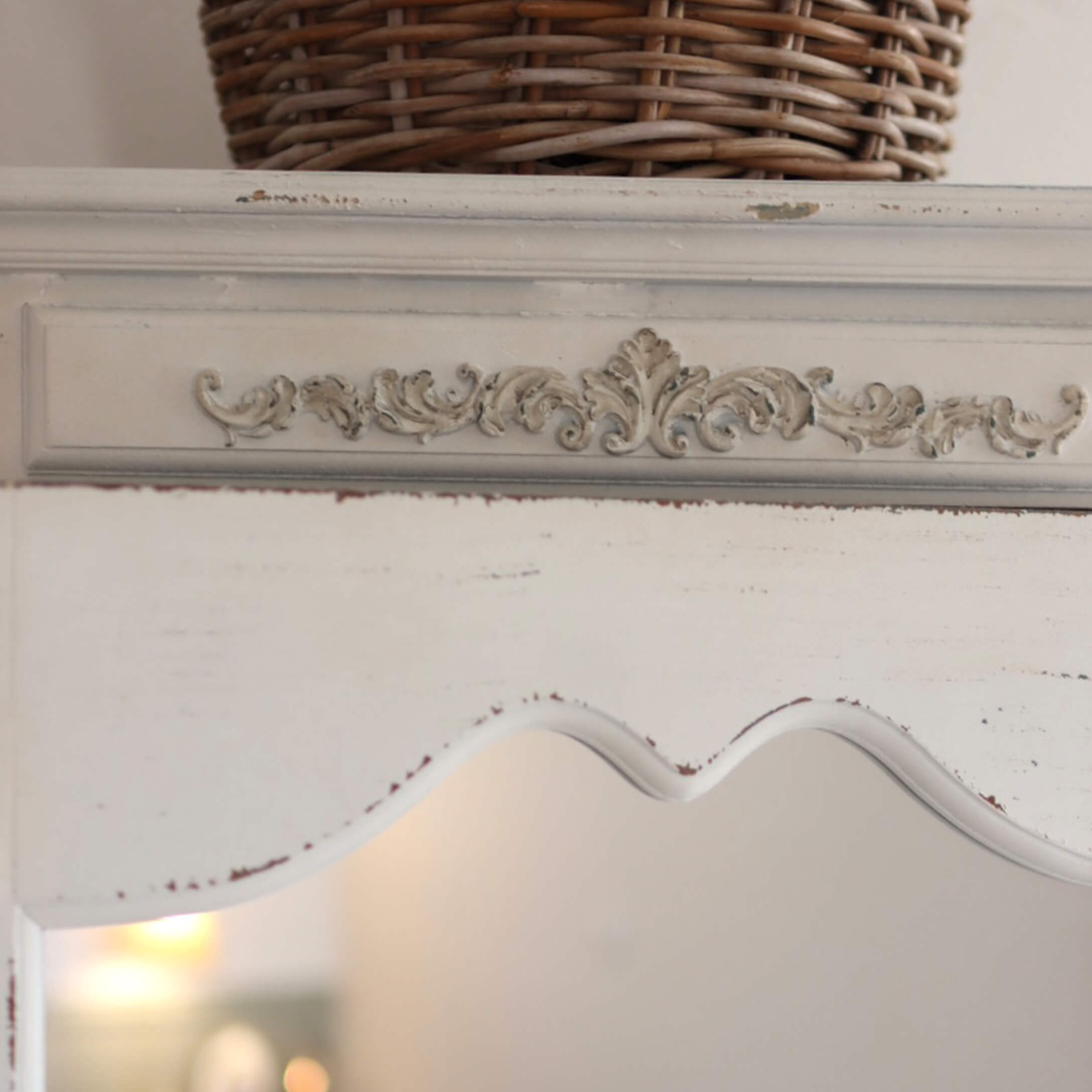 Meuble en bois blanc avec motif sculpté décoratif et finition vieillie pour un style vintage