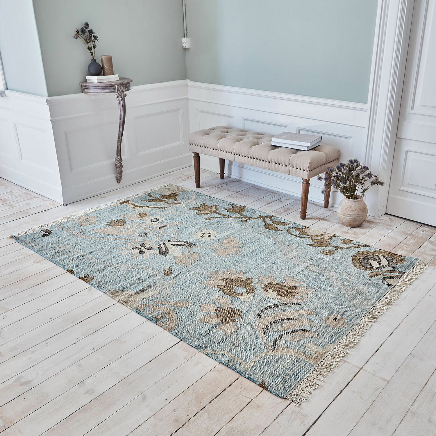Vloerkleed Nére Katoenen vloerkleed in blauw en beige met bloemmotief op lichte houten vloer in woonkamer
