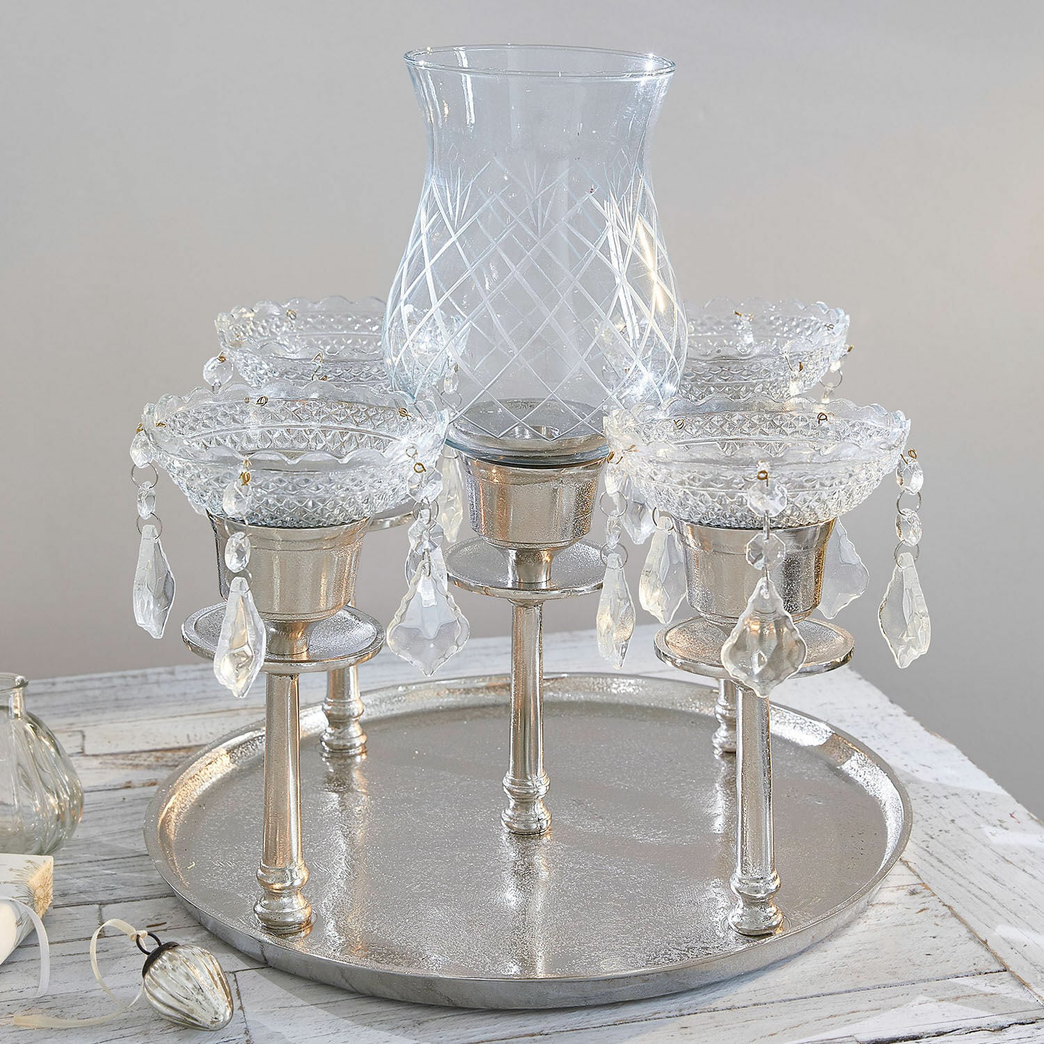 Chandelier décoratif en verre et métal argenté avec cristaux suspendus sur un plateau rond