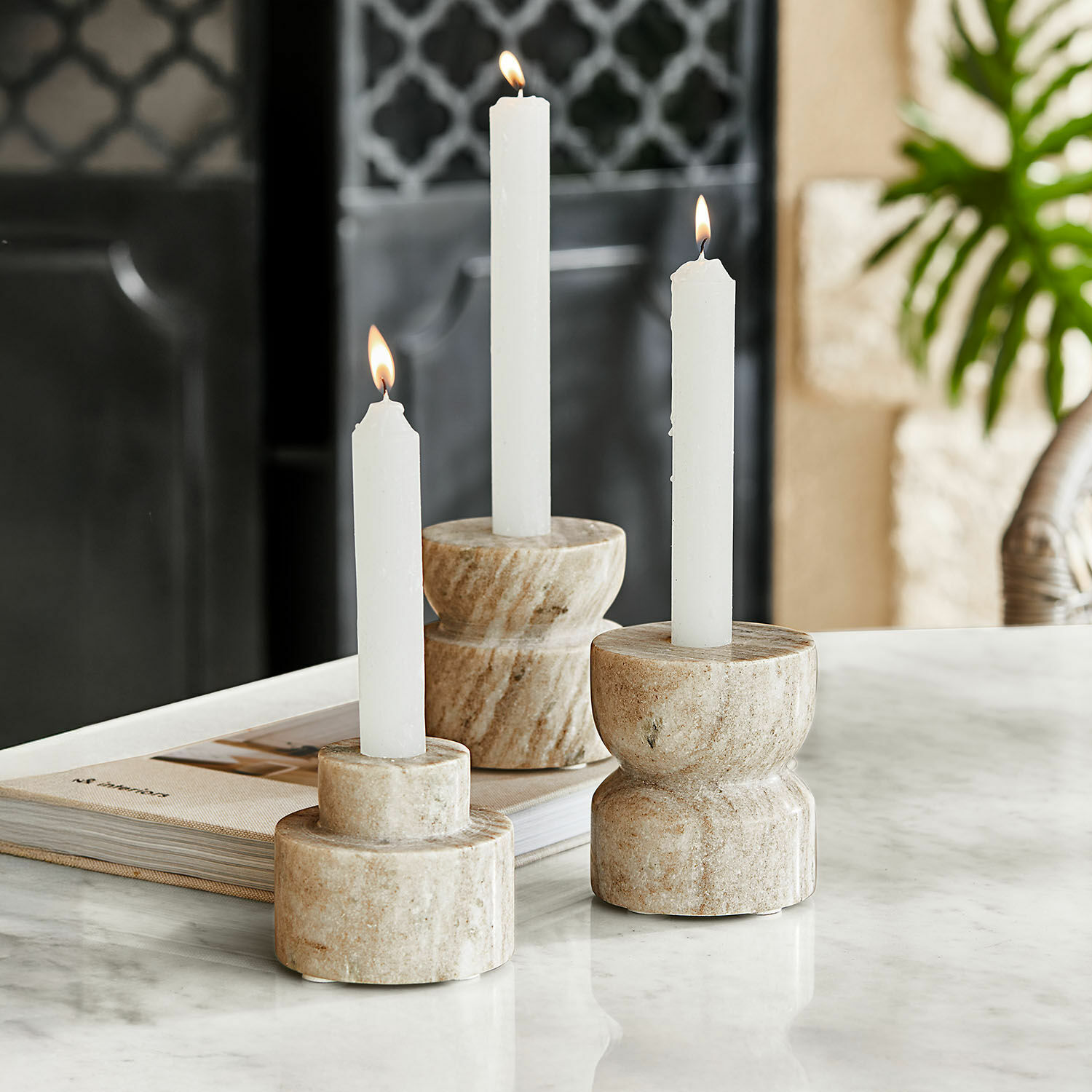 Kaarsenhouder set van 3 Ulxeno Set van drie beige marmeren kandelaren met witte kaarsen op een marmeren tafel, interieurdecoratie