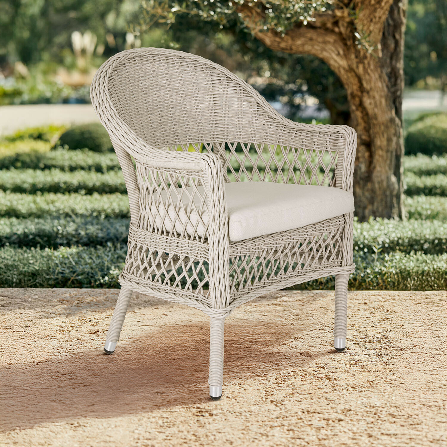 Fauteuil en rotin beige avec coussin clair, parfait pour terrasse et jardin, mobilier extérieur