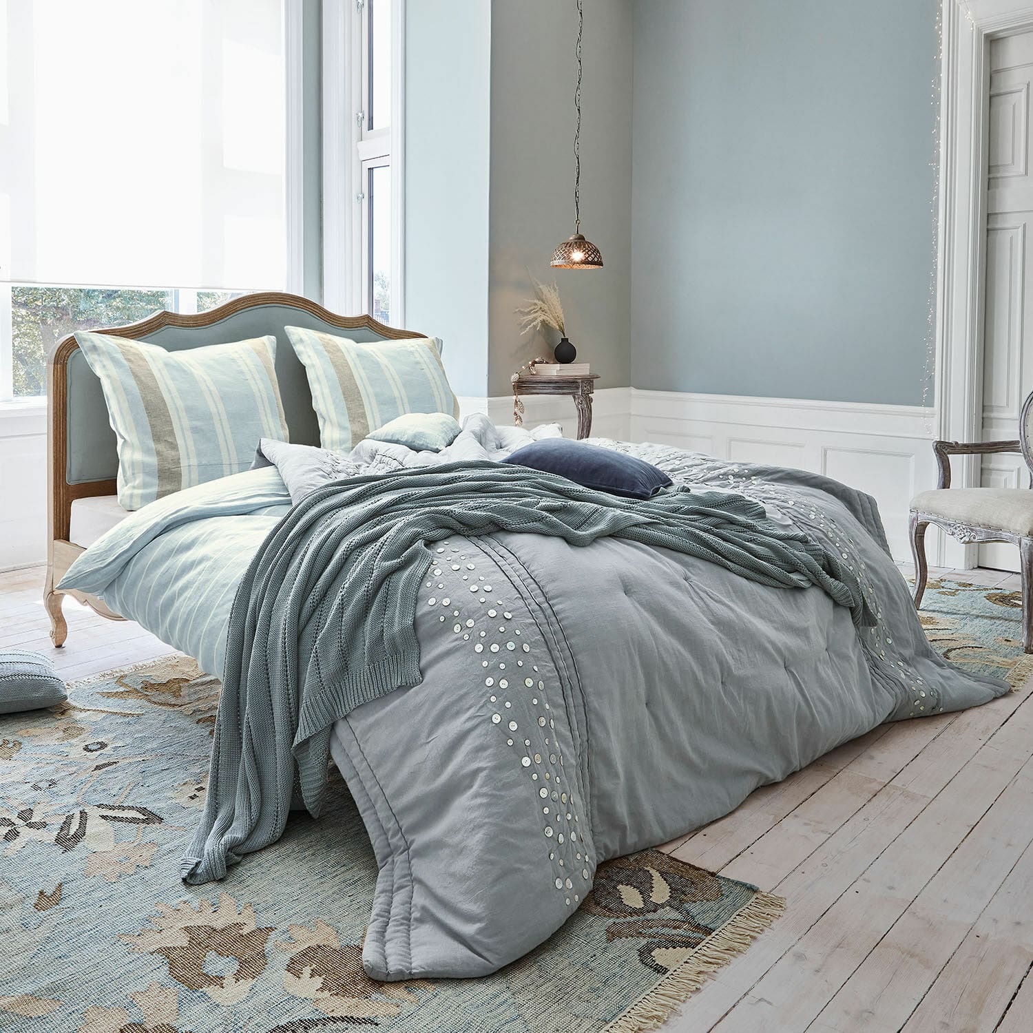Lit Serravalle Chambre avec lit bleu, linge de lit en coton orné de boutons décoratifs et plaid assorti