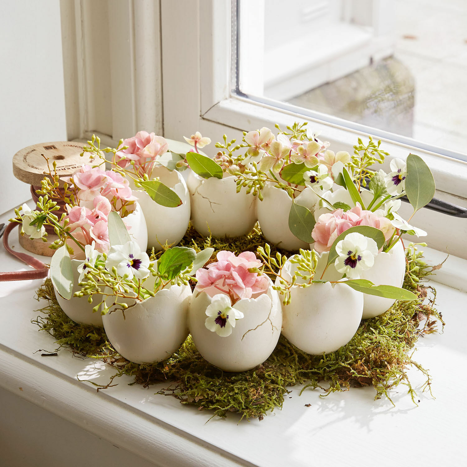 Vazenkrans Civiti Decoratieve krans van witte keramische eierschalen met roze en witte bloemen op mos