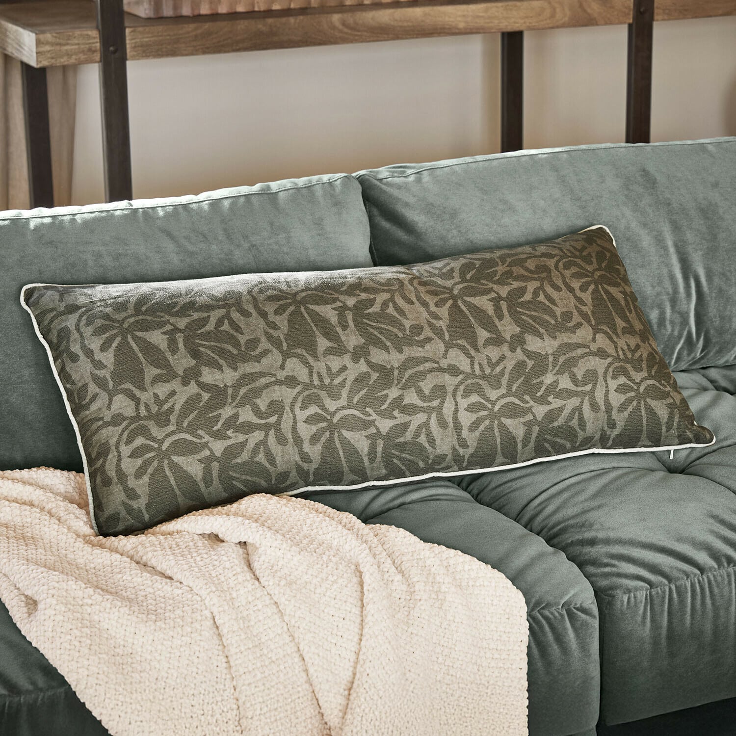 Coussin Rosamound Coussin décoratif allongé vert avec motif floral sur canapé vert doux avec couverture beige