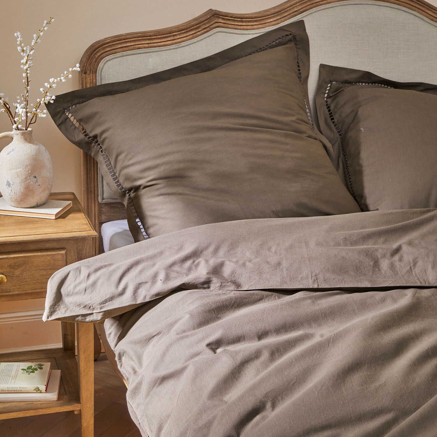 Beddengoed Belvero Bruine katoenen beddengoed op bed met houten hoofdeinde en nachtkastje met vaas