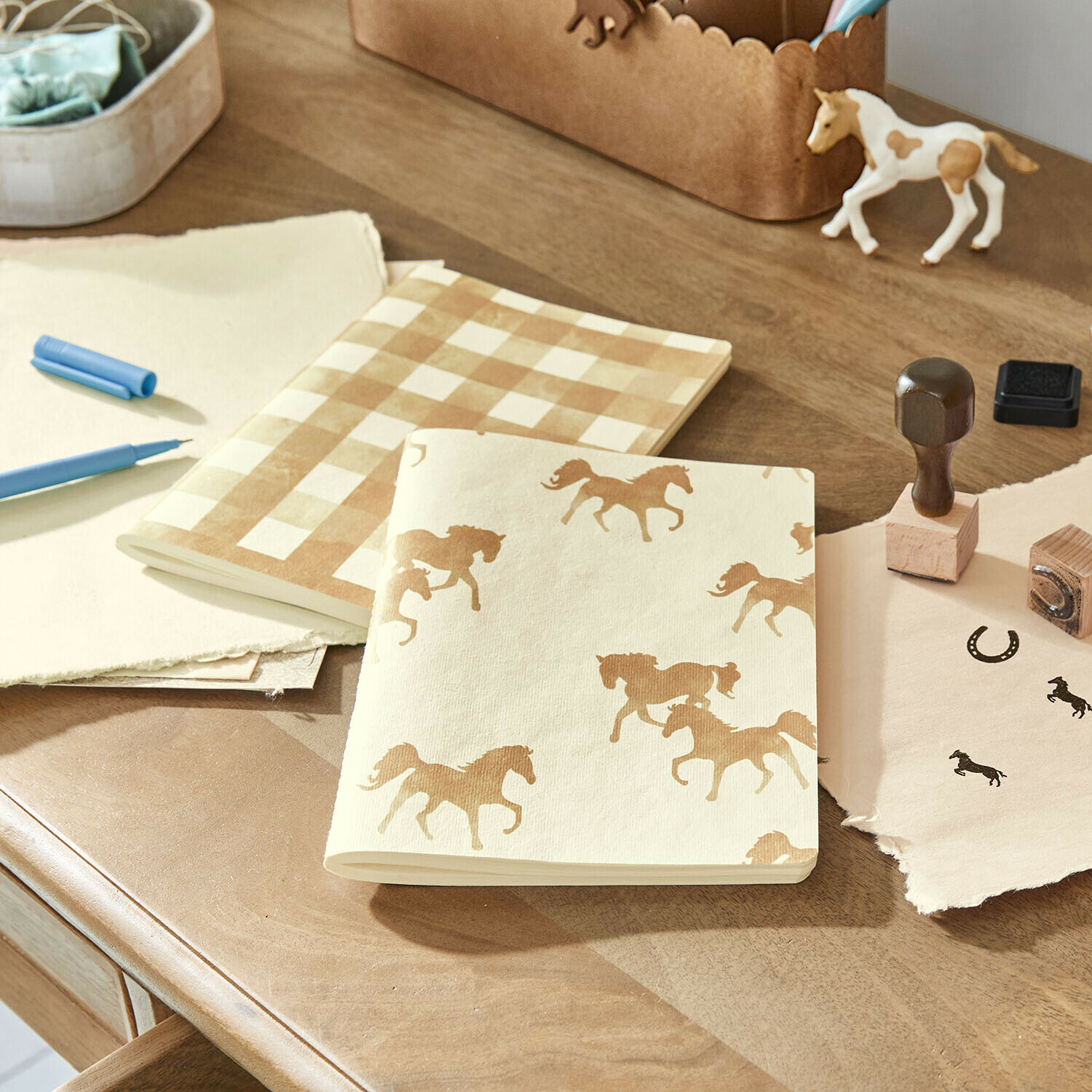 Notitieboekje set van 2 Windermay Notitieboekjes van crèmekleurig papier met paarden- en ruitpatroon op houten bureau met stempels