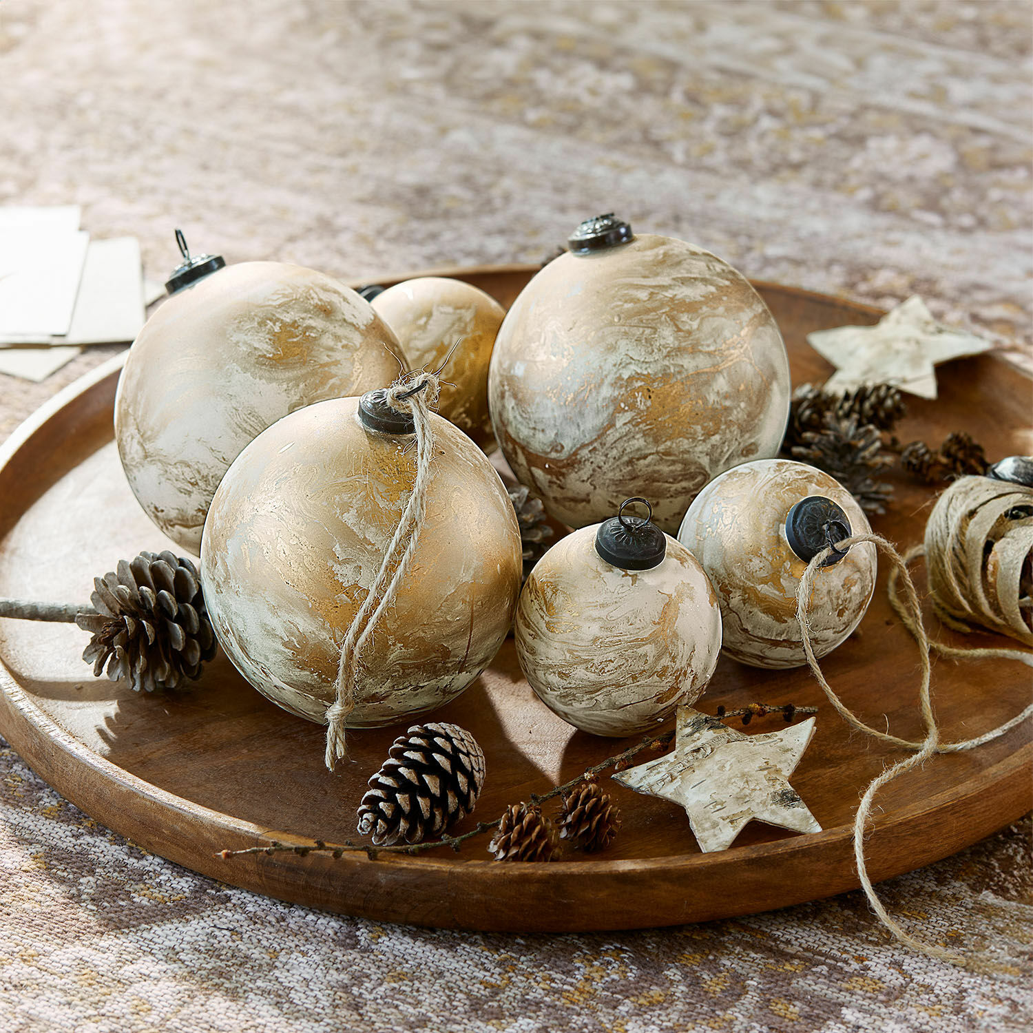 Kerstballen set van 6 Nymeria Set goud-beige kerstballen met natuurlijke dennenappels op decoratief houten dienblad