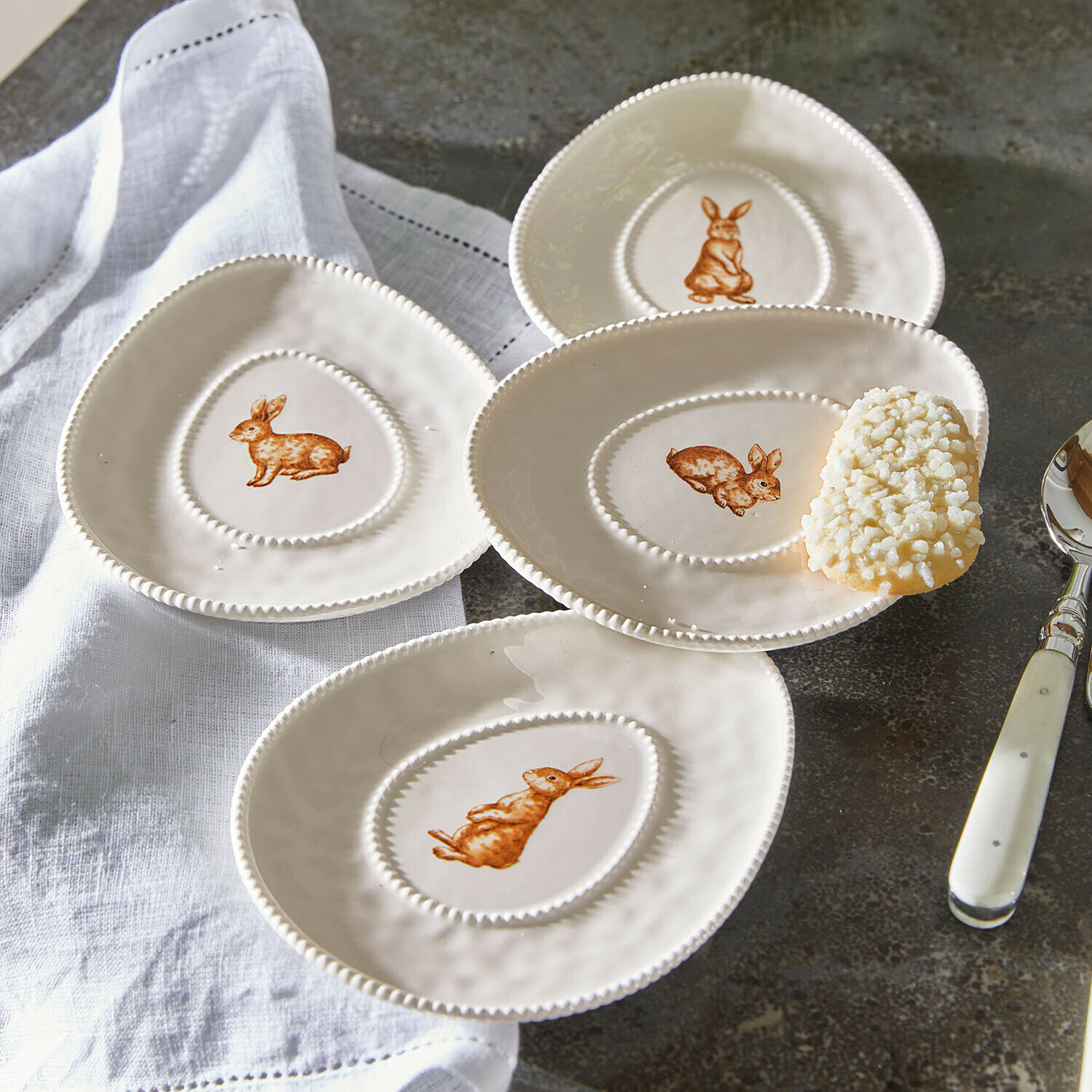 Lot de 4 assiettes Seravoux Ensemble de quatre assiettes en céramique crème avec lapins bruns, service décoratif pour table.