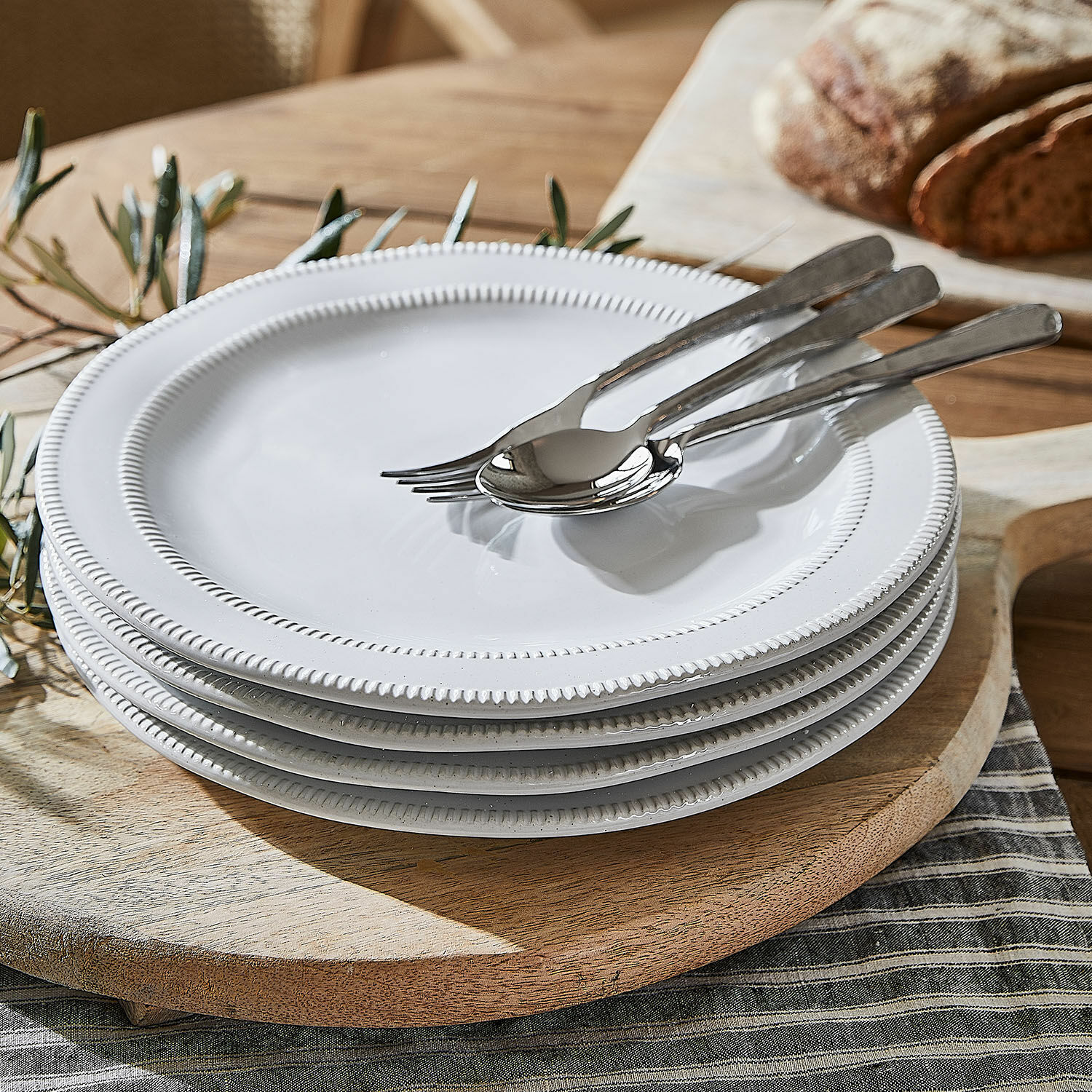 Groot bord set van 4 Alentejo Set witte keramische borden met decoratieve rand op een houten snijplank