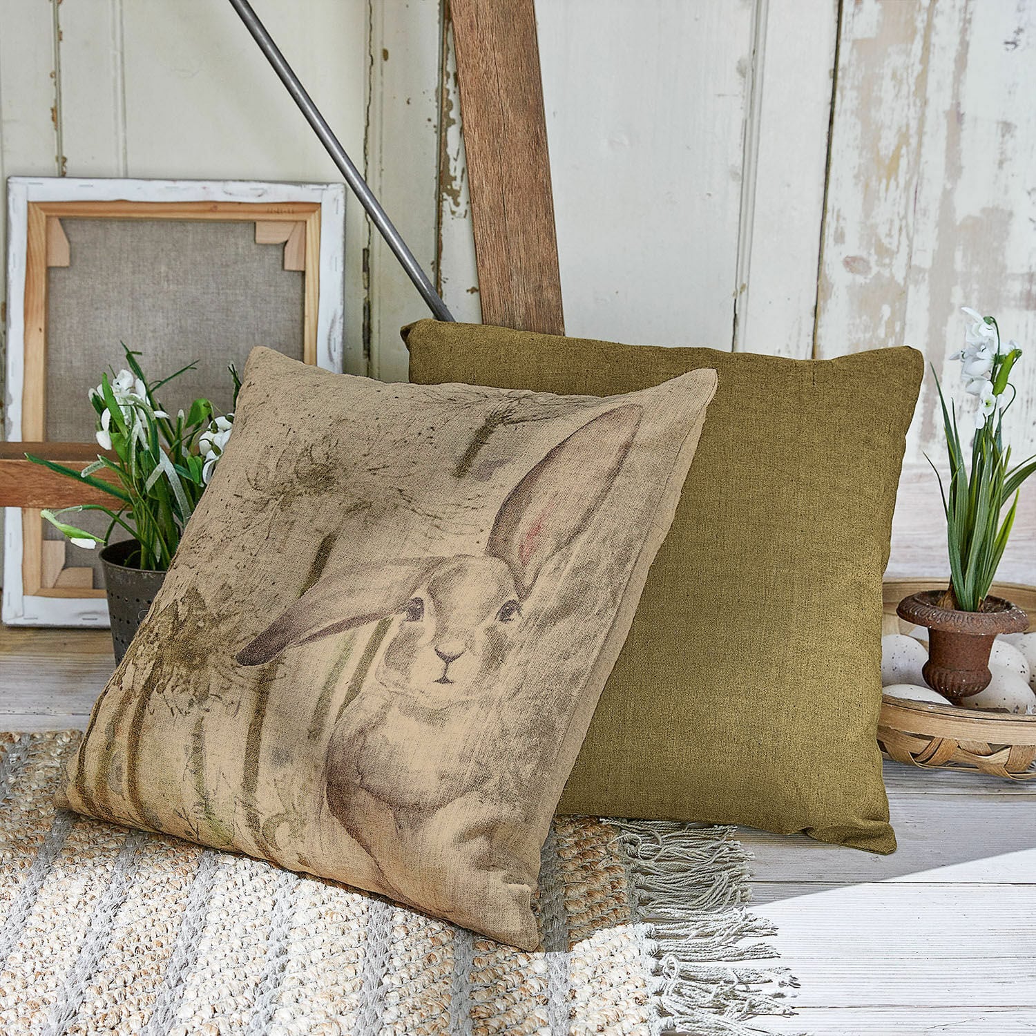 Kussenhoes set van 2 Milda Beige kussen met konijnenprint en groen sierkussen op gevlochten tapijt