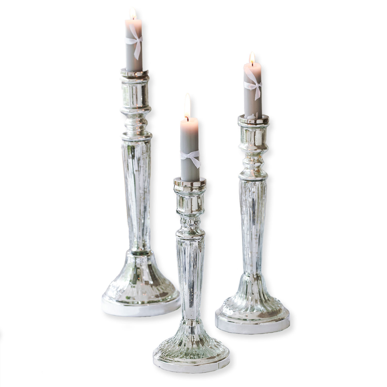 Ensemble de trois chandeliers argentés avec bougies grises et rubans blancs, décoration élégante