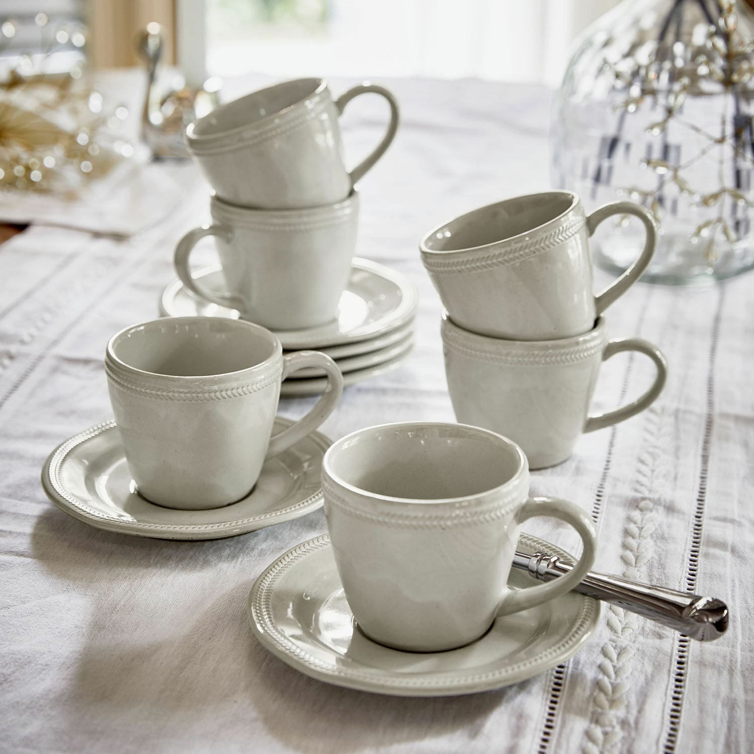 Kopje met schoteltje set van 6 Norrvik Set witte keramische kopjes met schotels op een wit tafelkleed voor koffie en thee
