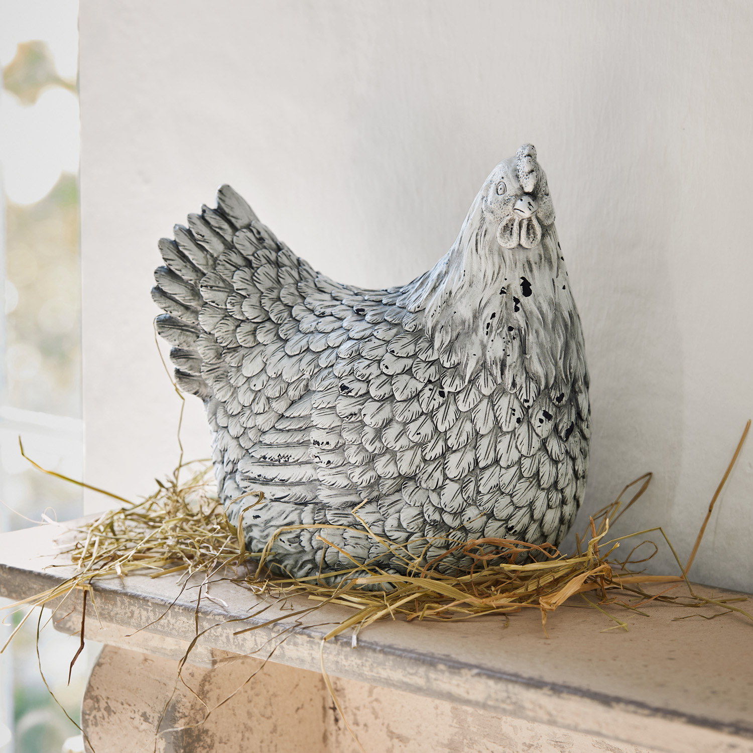 Figurine décorative de poule en céramique grise posée sur de la paille, décoration intérieure