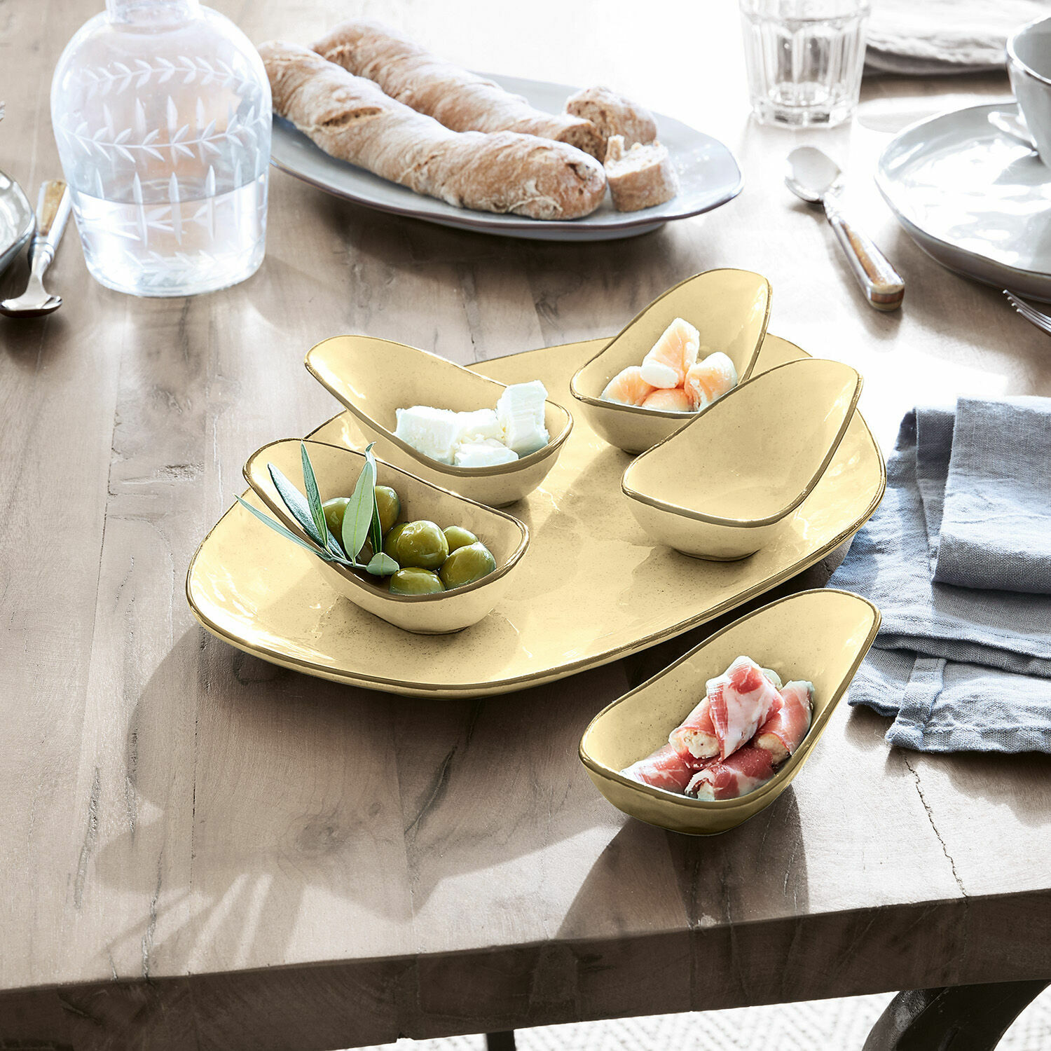 Serveerschaal set van 6 Biarré Set gele keramische schaaltjes voor snacks op houten tafel met olijven en kaas