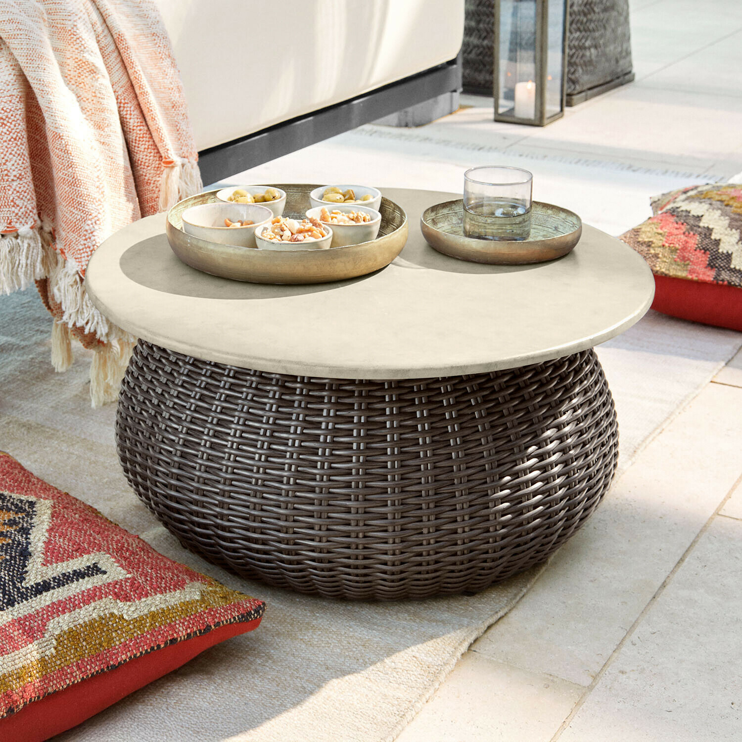 Ronde salontafel van bruin rattan met lichte blad, perfect voor tuin en terras