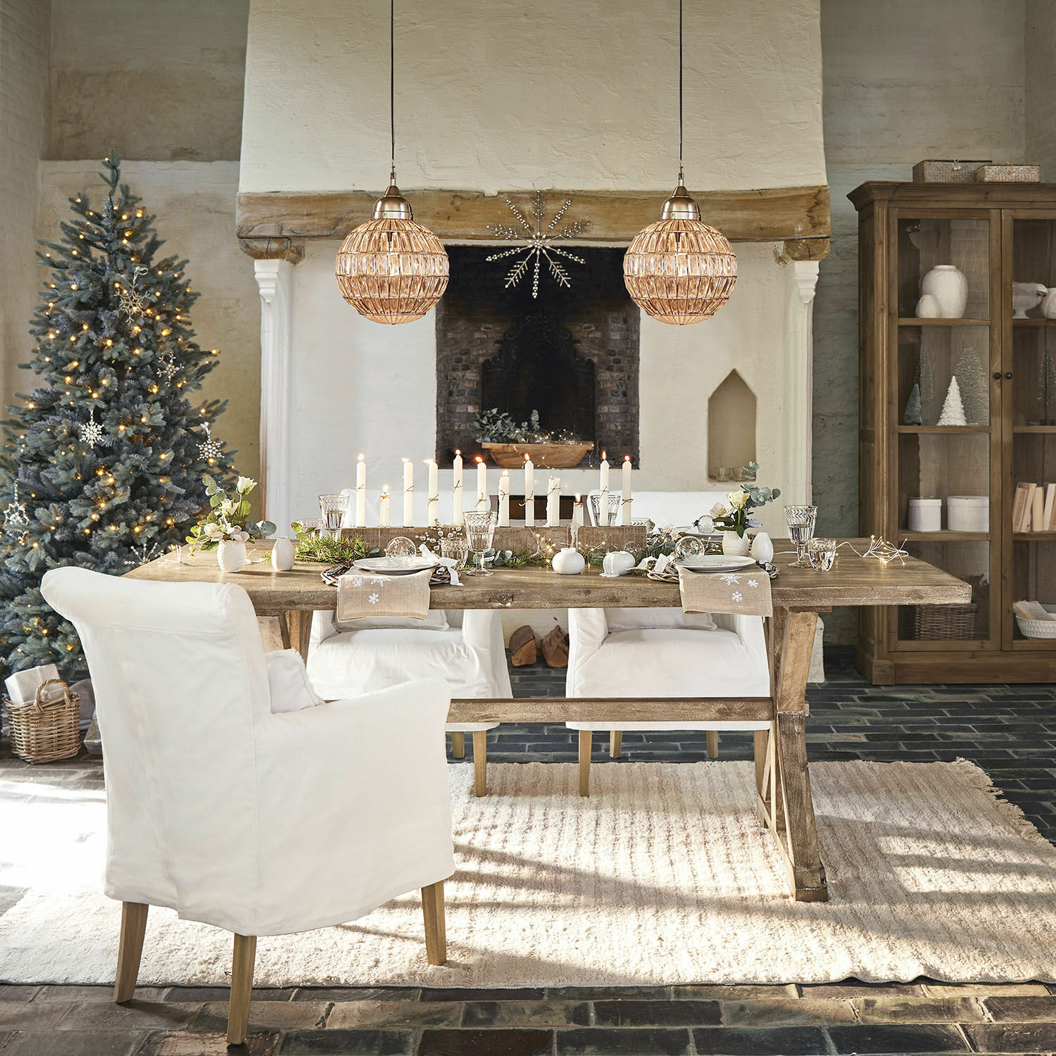 Table Dolignon Table en bois rustique avec chaises blanches et décoration de Noël dans un salon chaleureux avec cheminée