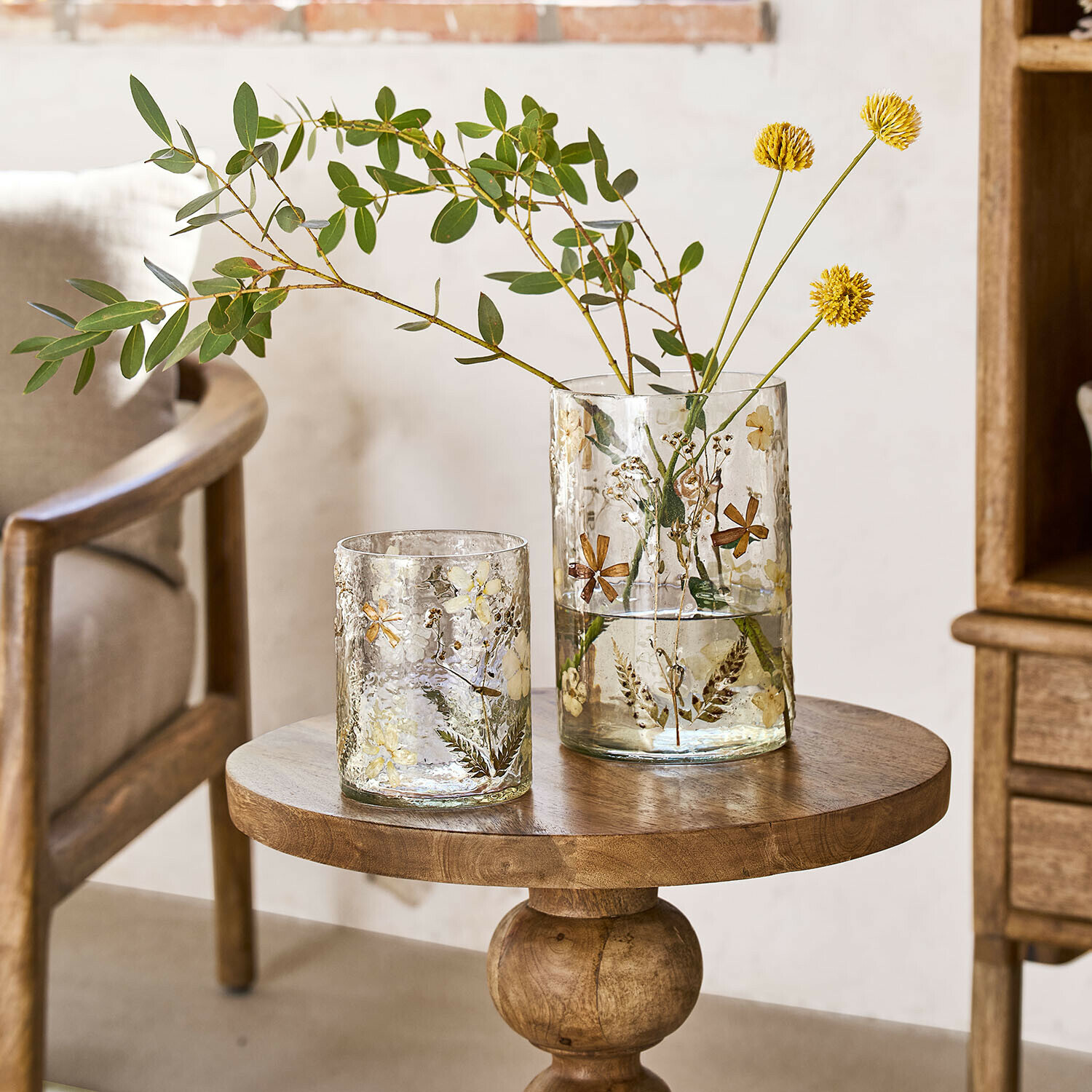 Vaas set van 2 Coudrisse Glazen vazen met gedroogde bloemen en bladeren op houten tafel in lichte kamer