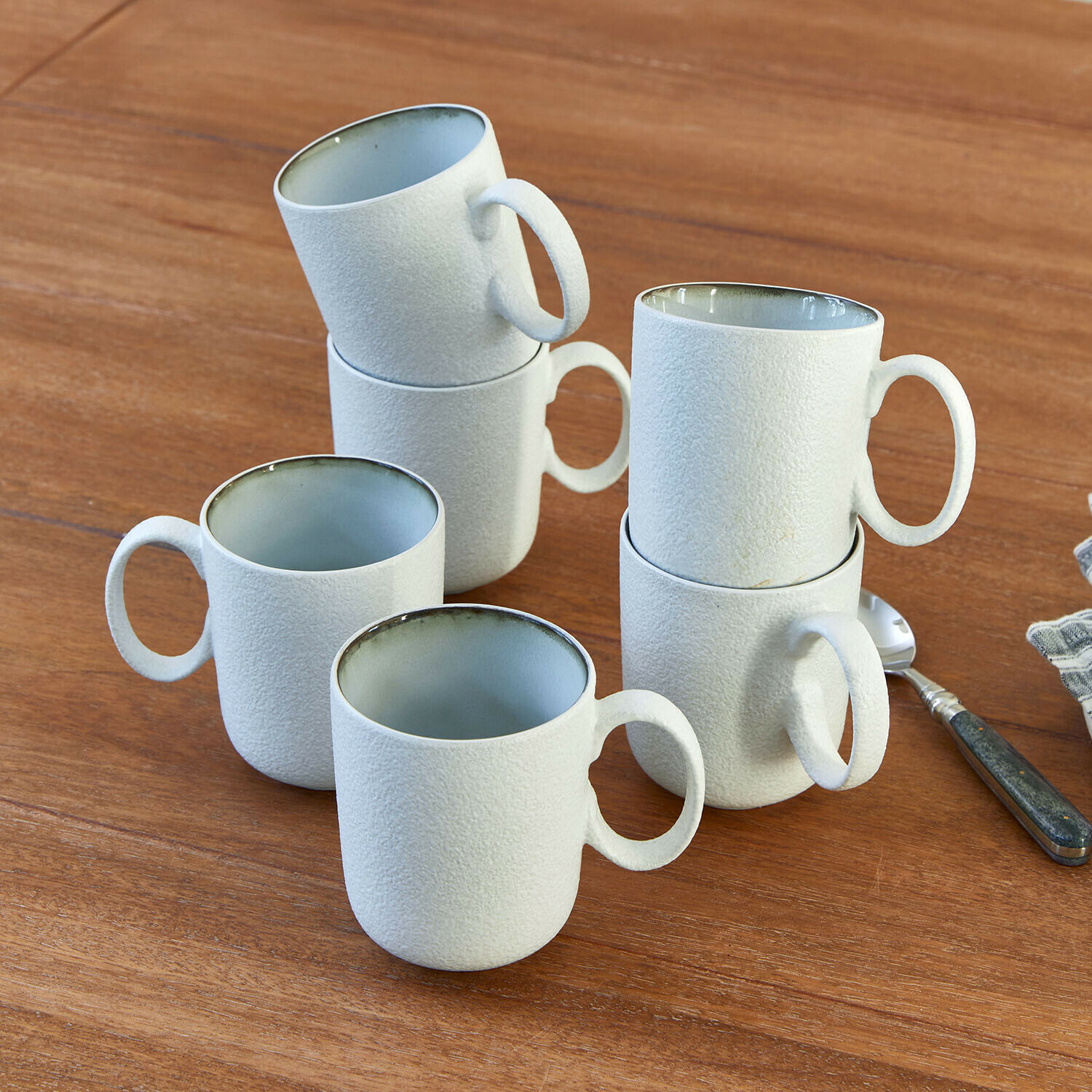 Kopje set van 6 Eiruna Set van zes witte keramische mokken met gestructureerd oppervlak op houten tafel