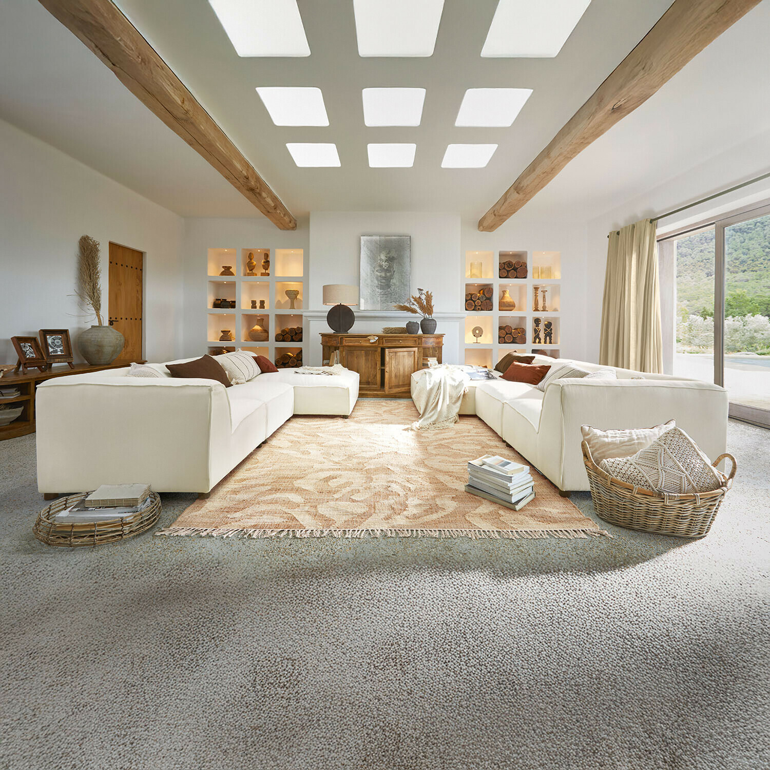 Bank McLean Ruime woonkamer met witte bank, houten balken, natuurlijke decoraties, beige vloerkleed en groot raam