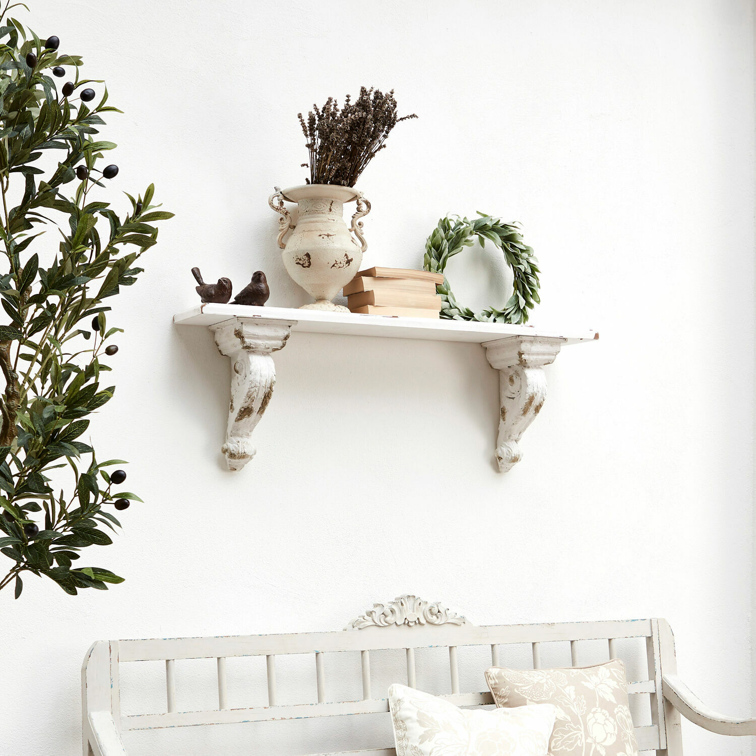 Wandplank Mouscron Witte houten wandplank met decoratieve beugel, vaas, boeken en groene krans