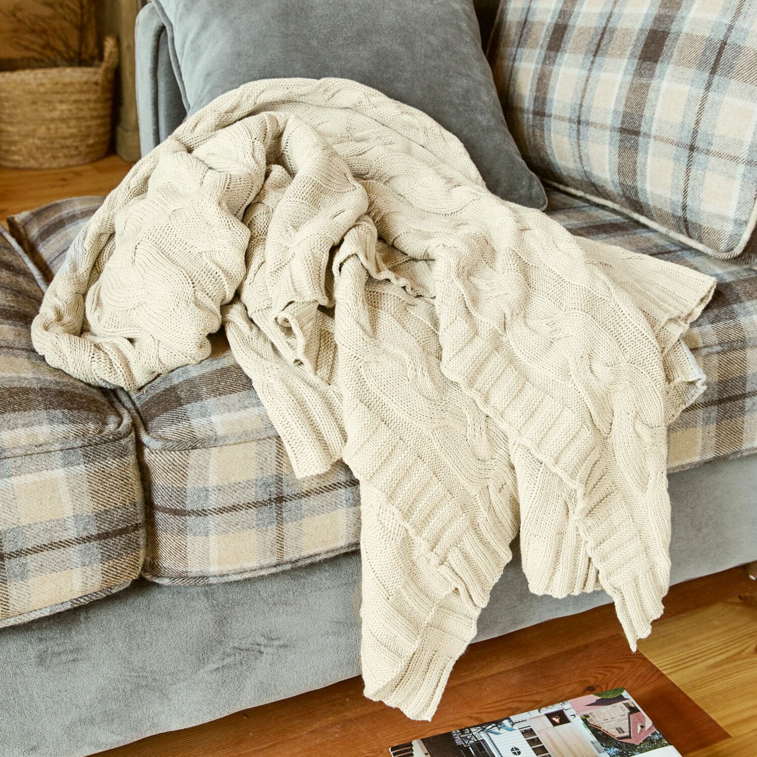 Plaid Arnhem Beige gebreide katoenen deken op grijze bank met beige ruitpatroon in woonkamer