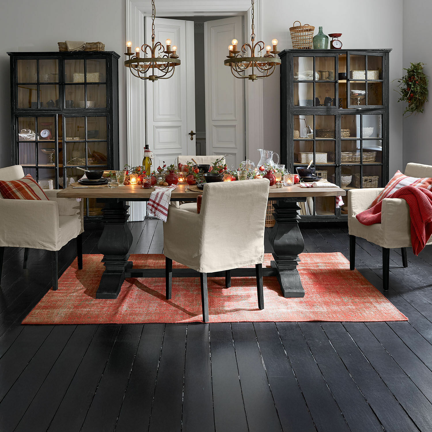 Tapis Yalora Salle à manger avec table en bois et chaises beige sur tapis rouge, ambiance rustique chaleureuse