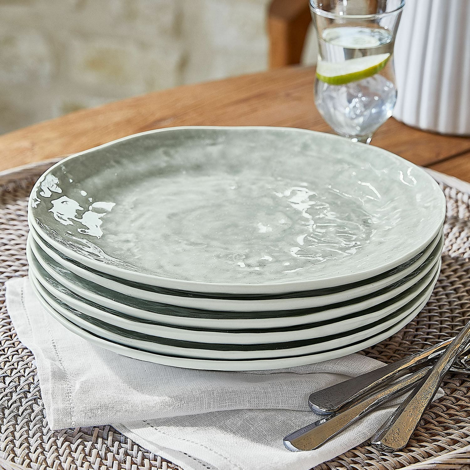 Bord set van 6 Braganza Set van zes grijze keramische borden op linnen servet met metalen bestek op tafel