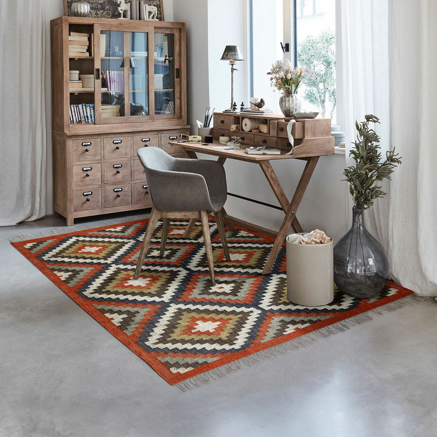 Vloerkleed Dailies Vloerkleed met geometrisch patroon in warme kleuren in moderne werkkamer met houten bureau en kast