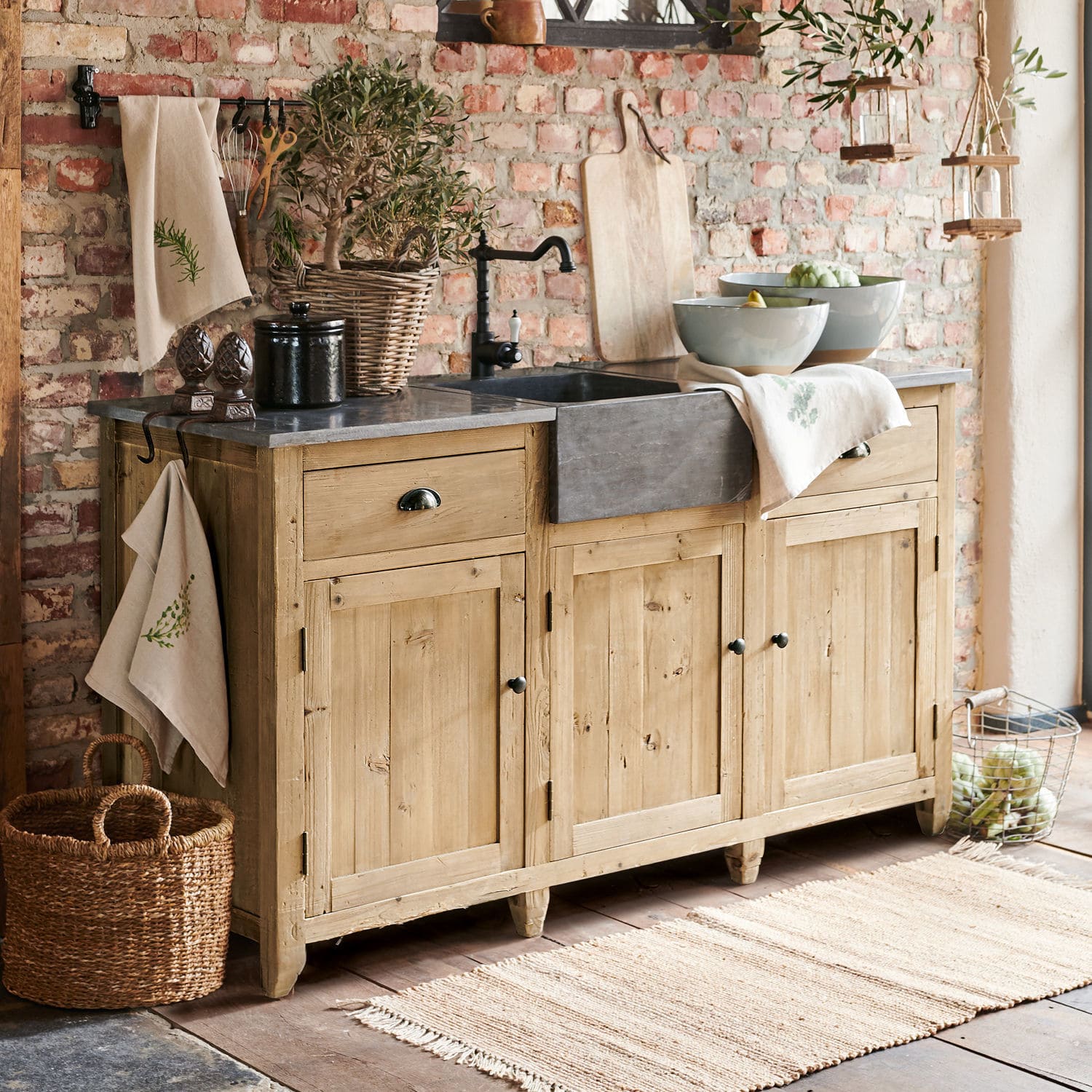 Meuble avec évier Deaton Buffet rustique en bois avec évier en pierre et décorations vintage dans une cuisine chaleureuse