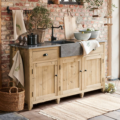 Buffet en bois avec évier en béton et robinet noir, style rustique avec éléments naturels et décorations