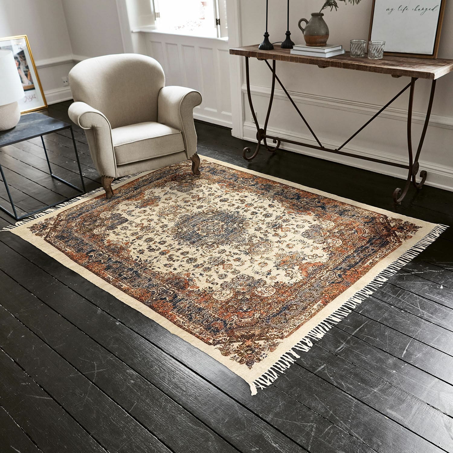 Vloerkleed Aleixo Decoratief vloerkleed met franjes in crème- en bruintinten op donkere houten vloer