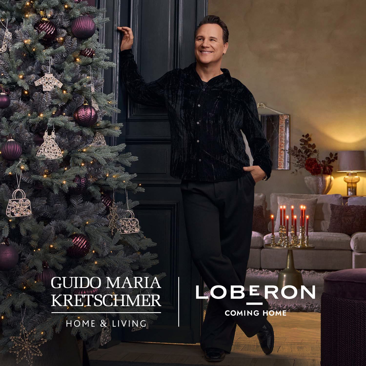 Homme en chemise noire debout près d'un sapin de Noël décoré de boules violettes et d'ornements dorés
