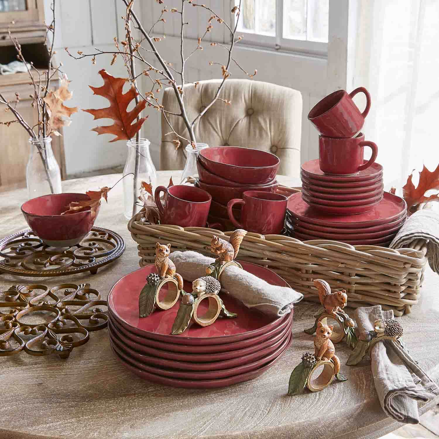Rode keramische servies set met mokken en borden op houten tafel met herfstdecoratie