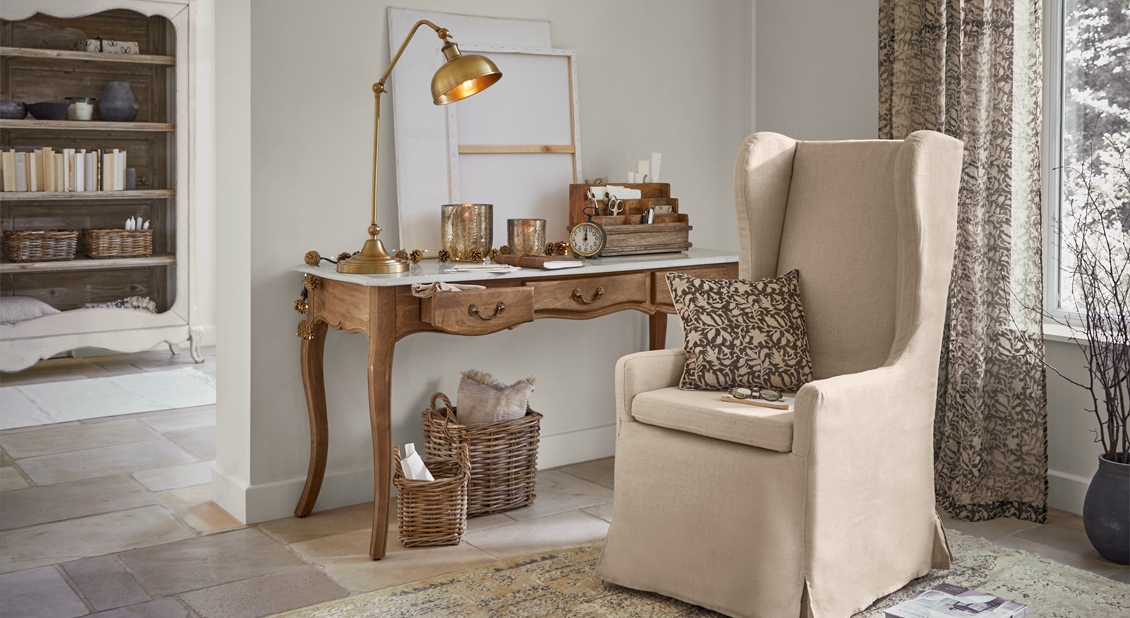 Fauteuil beige style oreiller avec coussin et bureau en bois avec lampe dans un salon chaleureux et décor naturel