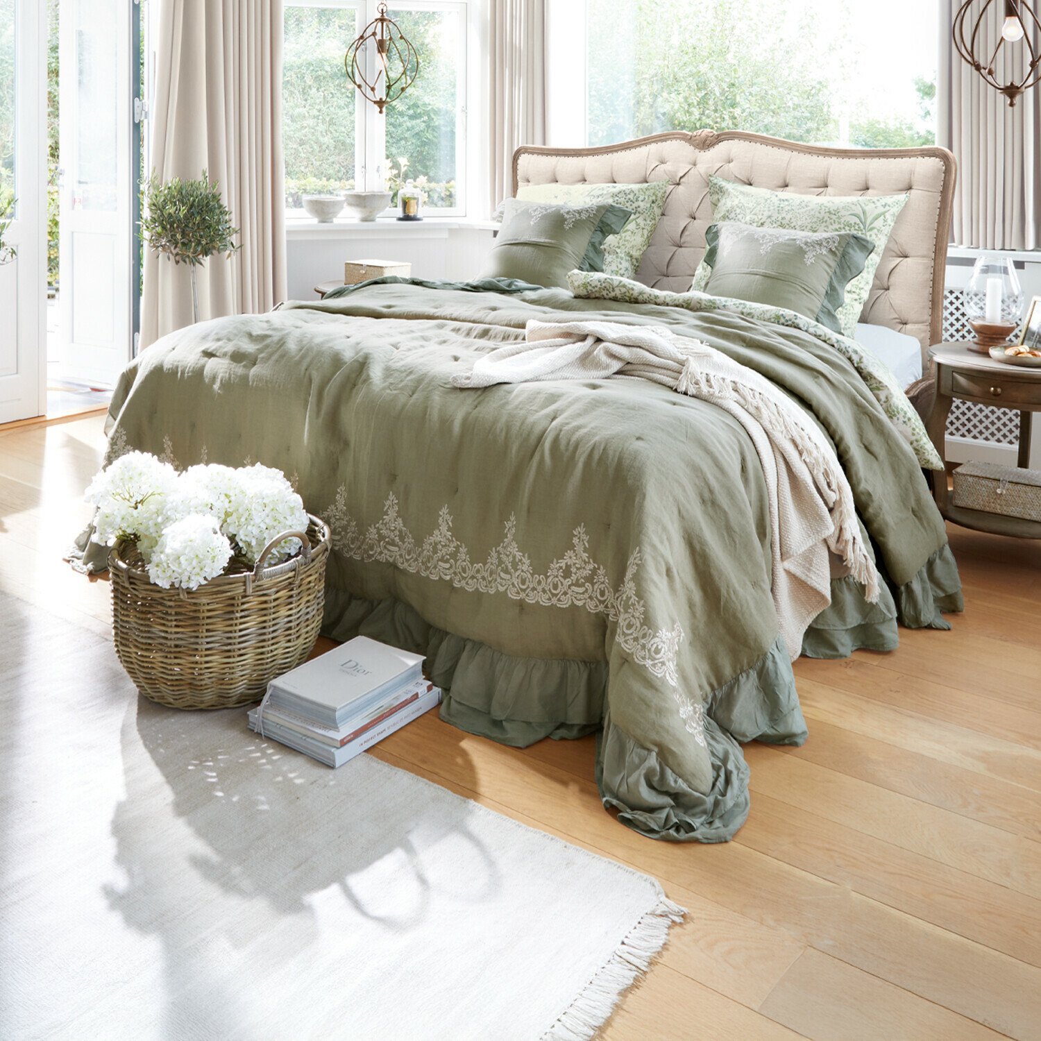 Courtepointe Therese Chambre avec lit à tête capitonnée beige et linge de lit vert en lin avec broderie décorative
