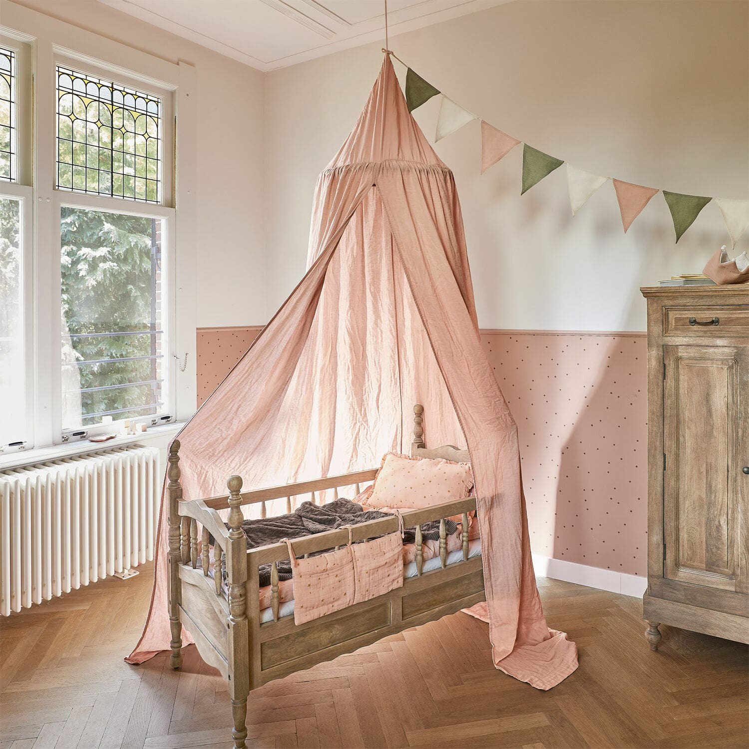 Bedhemel Lisonne Houten kinderbed met roze baldakijn en decoratieve kussens in lichte kinderkamer