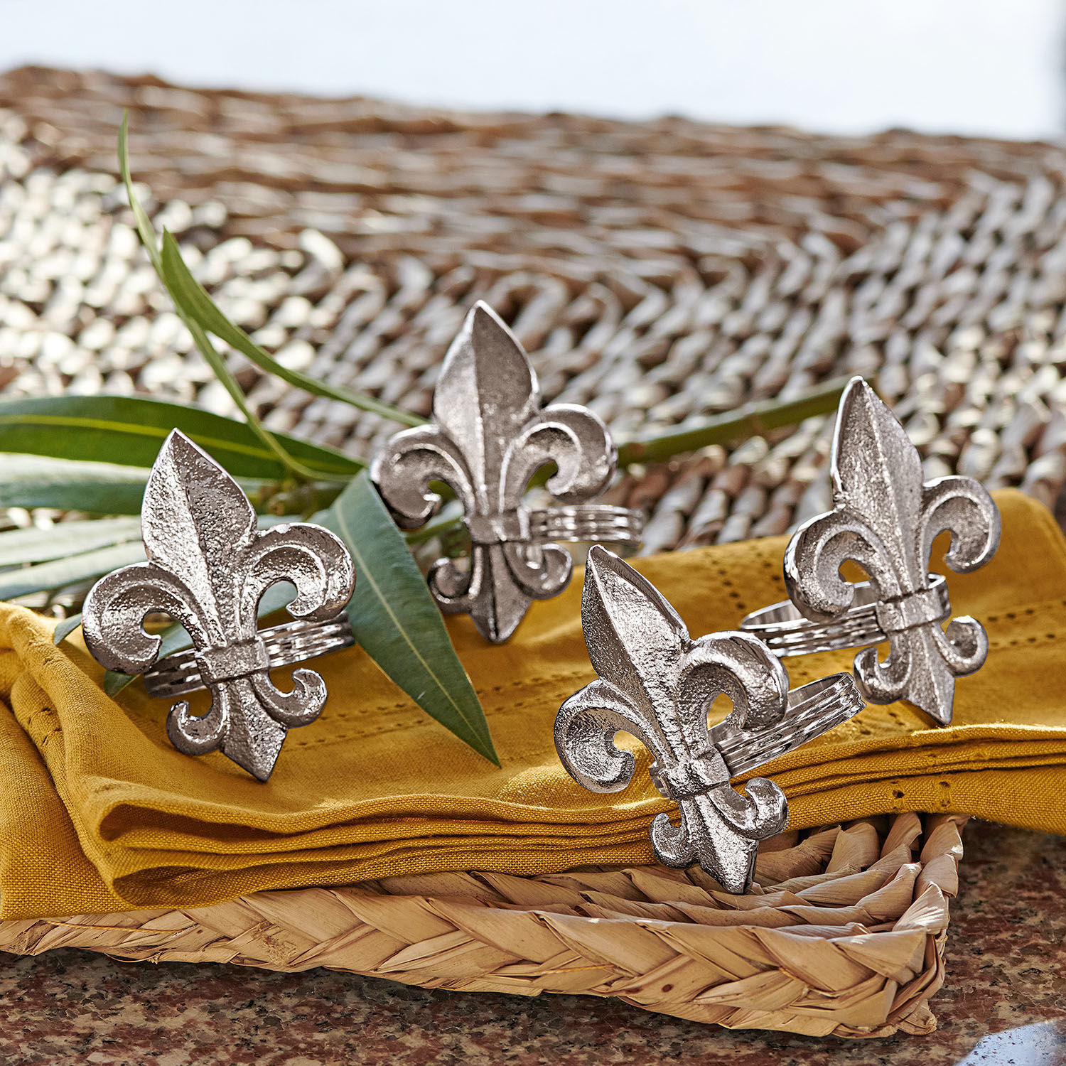 Servetring set van 4 Fleur De Lis Zilverkleurige metalen servetringen met lelie-motief op gele stof en gevlochten dienblad