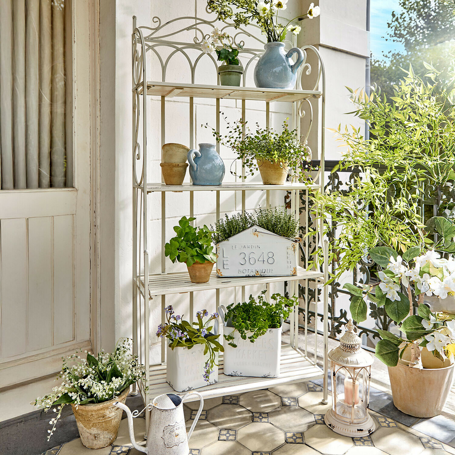 Rek Cruis Witte metalen plank met potplanten en decoraties op een lichte balkon
