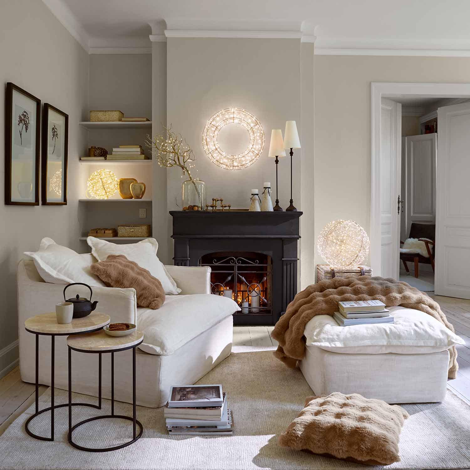 Gezellige woonkamer met witte bank, bruine kussens en decoratieve LED-lampen met warm licht